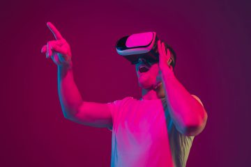 Caucasian man’s portrait isolated on pink-purple studio background in neon light, playing with VR-headset
